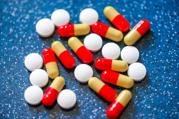 Red and white tablets capsules on a blue background