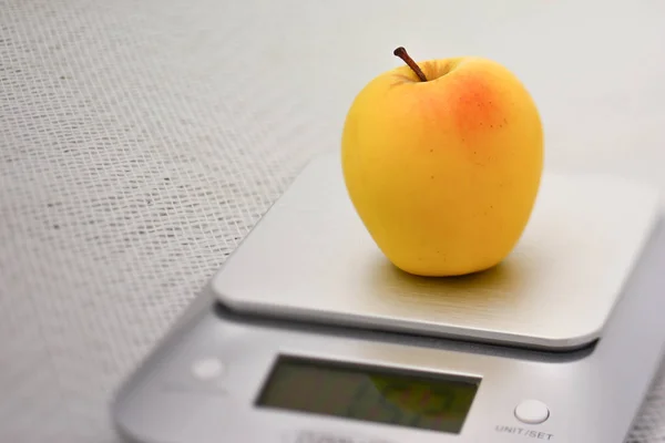 Única maçã dourada em uma balança de cozinha — Fotografia de Stock