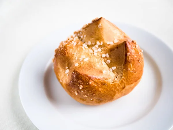 Single brioche, French  bun on a white plate and background — Stock Photo, Image