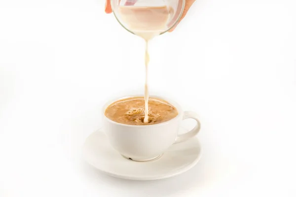 Pouring milk into coffee — Stock Photo, Image