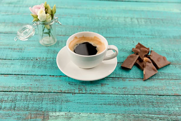 Kaffe Mugg steam och blommor på bord — Stockfoto