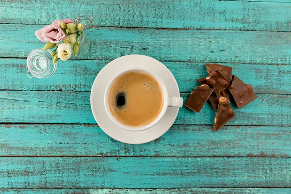 Taza de café vapor y flores en la mesa — Foto de Stock