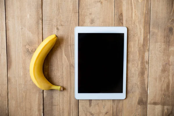 Banane und digitales Tablet — Stockfoto
