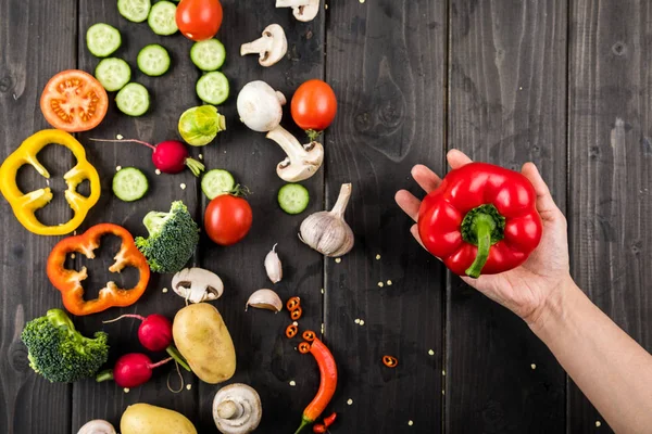 Legumes frescos e mão com pimenta — Fotografia de Stock