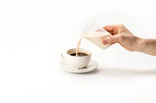 Milch in Tasse Kaffee gießen — Stockfoto