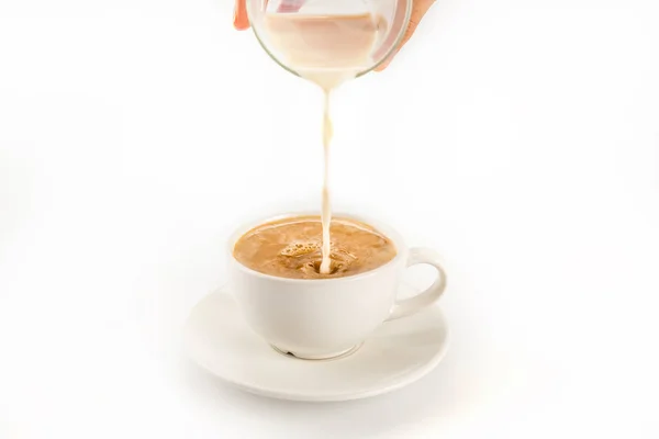 Pouring milk into coffee — Stock Photo