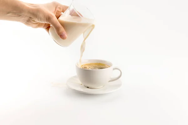 Pouring milk into coffee — Stock Photo