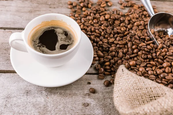 Kaffeetasse mit Dampf und Bohnen — Stockfoto