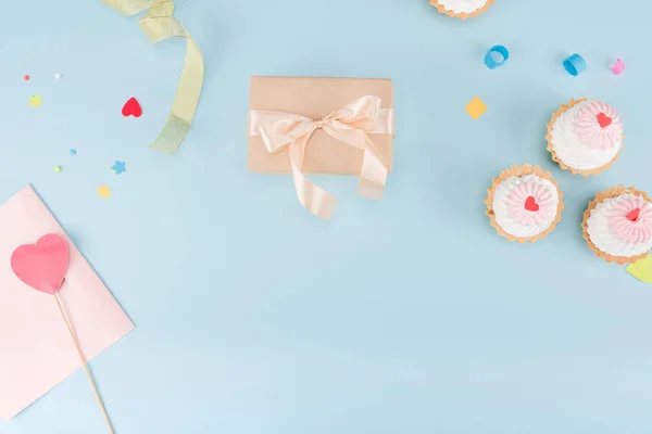 Cakes and gift box with ribbons — Stock Photo