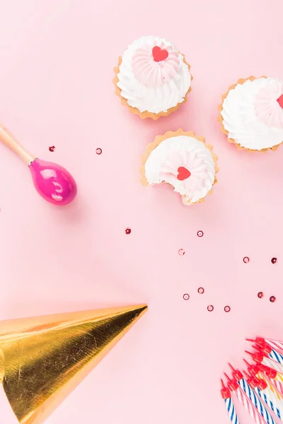 Cakes with candles and party hat — Stock Photo