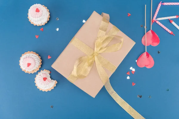 Gift box and cakes — Stock Photo