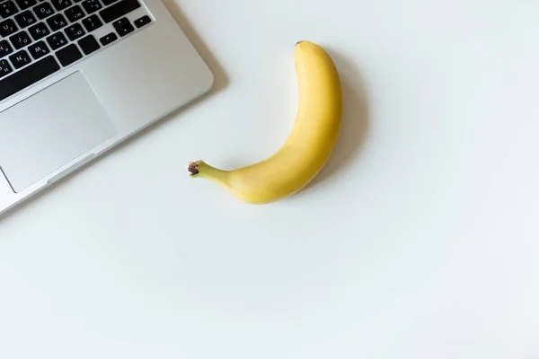 Ripe banana and laptop — Stock Photo