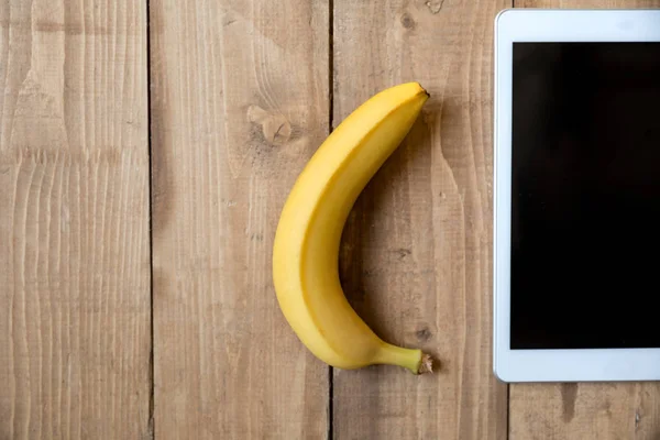 Banane et tablette numérique — Photo de stock
