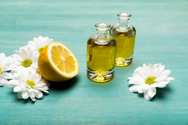 Essential oil with lemon and chamomiles — Stock Photo