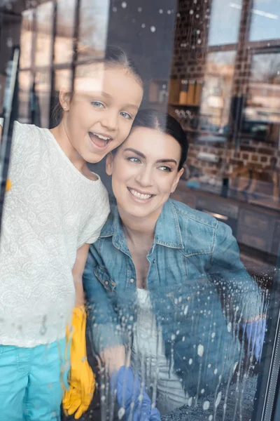 Mother and daughter cleaning window — Stock Photo, Image