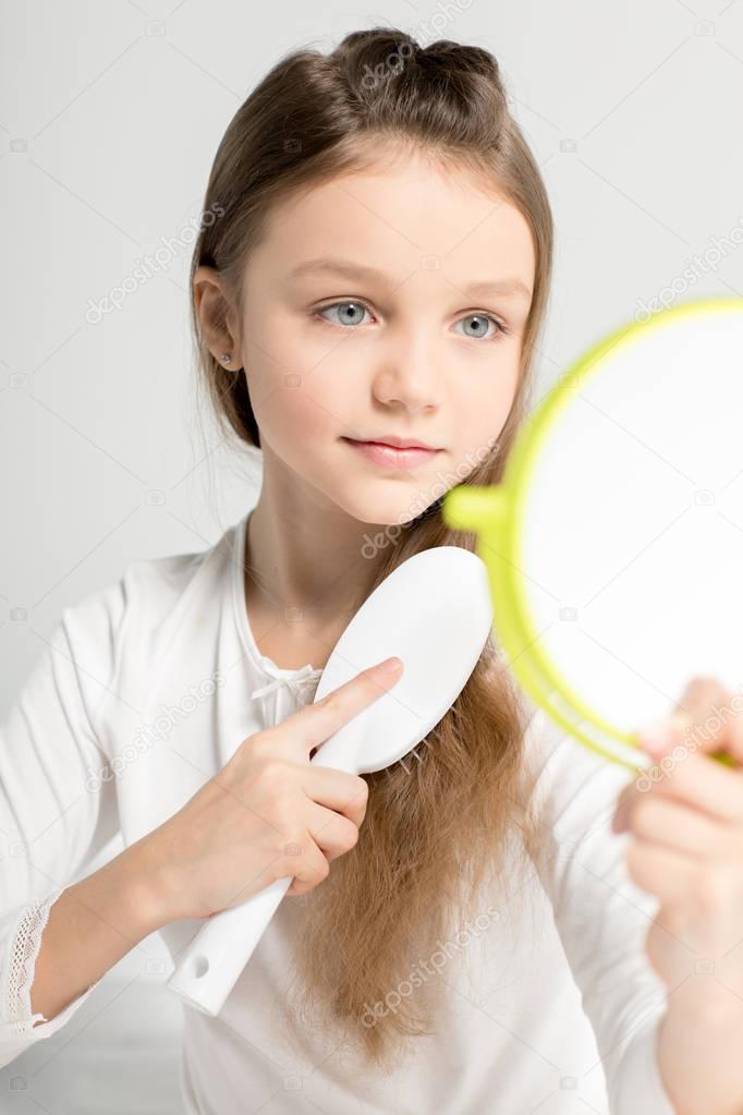 Little girl combing hair 