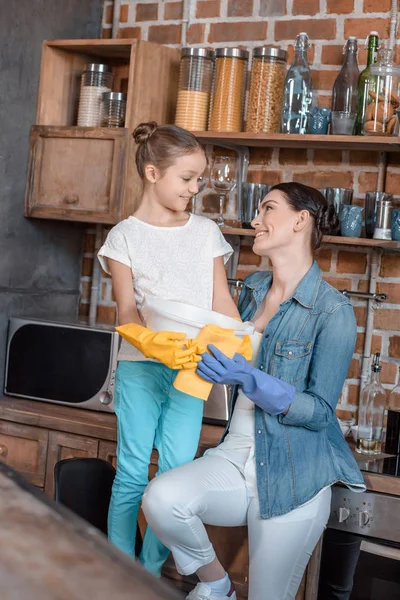 Hija ayudando a la madre con las tareas domésticas - foto de stock