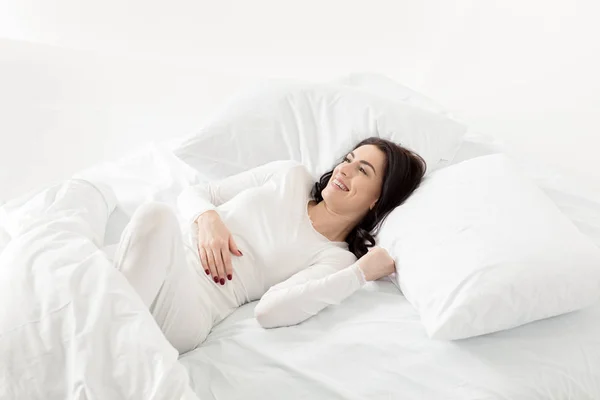 Жінка в сплячому одязі прокидається — стокове фото