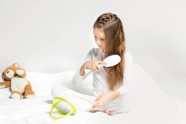 Little girl combing hair — Stock Photo