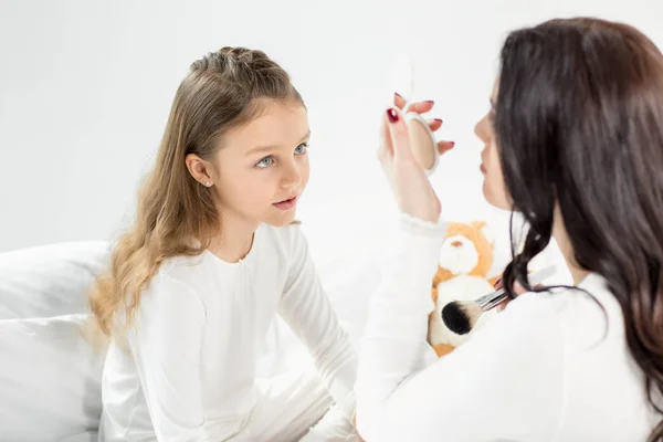 Madre e hija con espejo cosmético - foto de stock