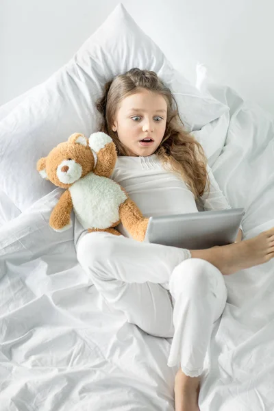 Menina com tablet digital na cama — Fotografia de Stock