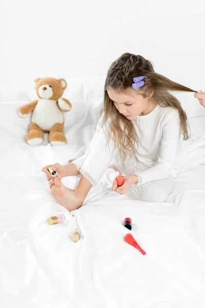 Chica aplicando esmalte de uñas - foto de stock