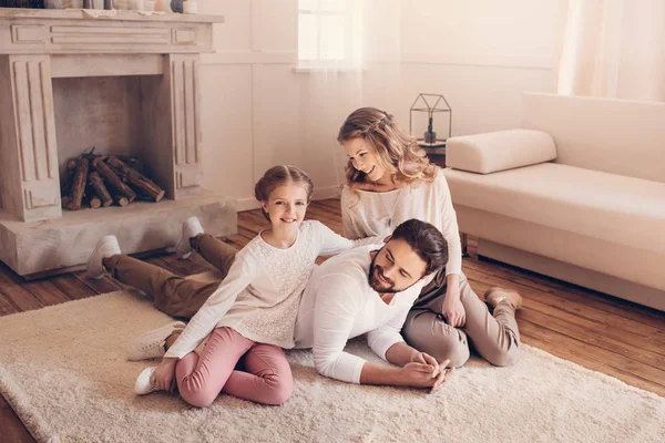 Jovem família feliz com uma criança passando tempo juntos em casa — Fotografia de Stock