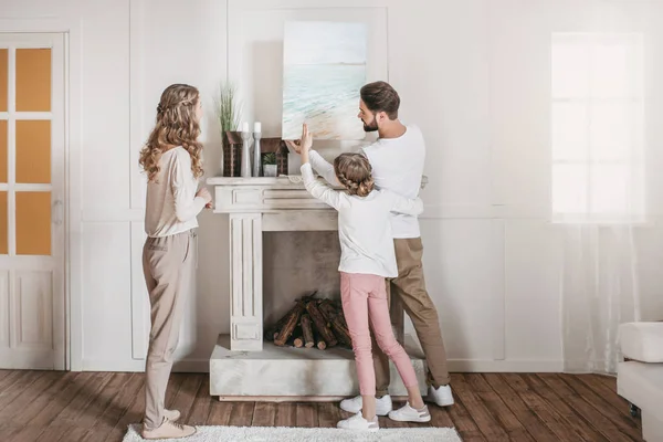 Felice famiglia appeso immagine del mare sopra il camino a casa — Foto Stock