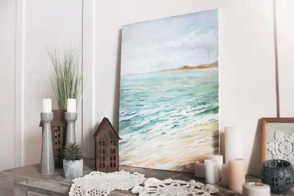 Obraz z morza, świecami i dekoracjami stoi na półce w domu — Zdjęcie stockowe