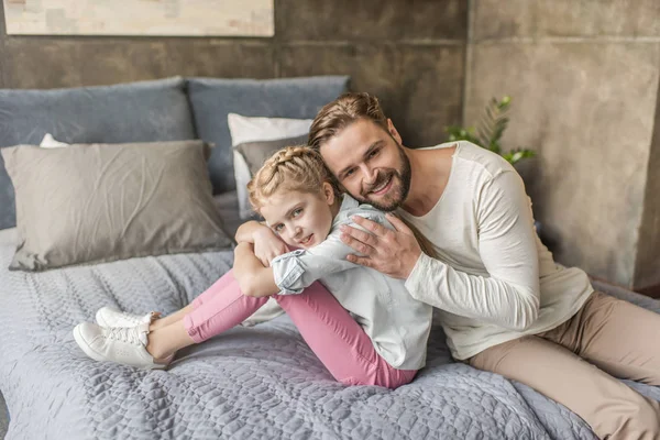 Mutlu çok güzel kızı ve babası evde yatakta oturuyor — Ücretsiz Stok Fotoğraf