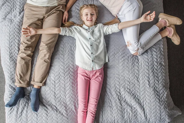 Boldog imádnivaló lánya, anya és apa ágyban otthon pihen — Stock Fotó