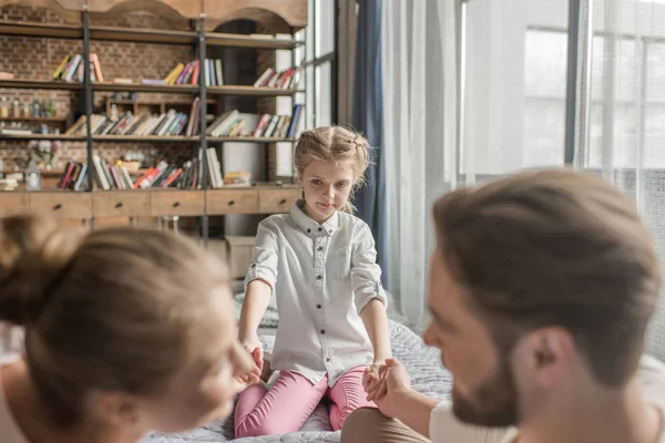 Adorable hija cogida de la mano con madre y padre en casa — Foto de Stock