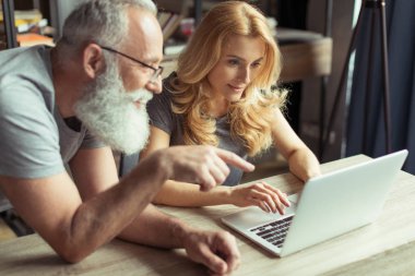 dizüstü bilgisayarda birlikte çalışan orta yaşlı çift