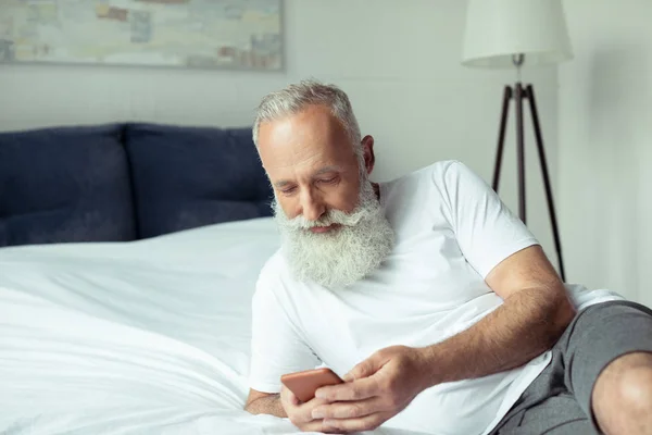 Homme âgé utilisant un smartphone — Photo