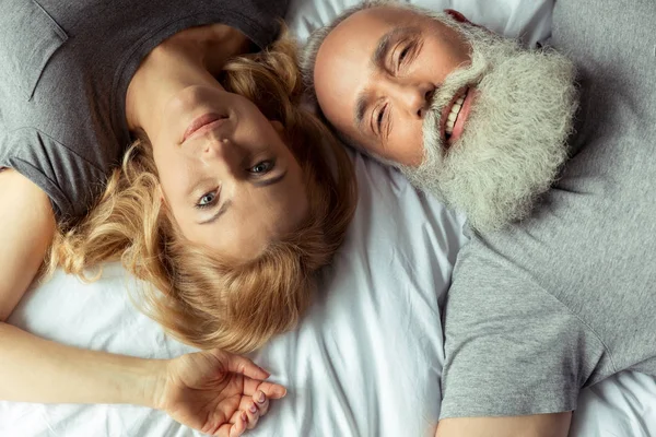 Paar mittleren Alters liegt im Bett — Stockfoto