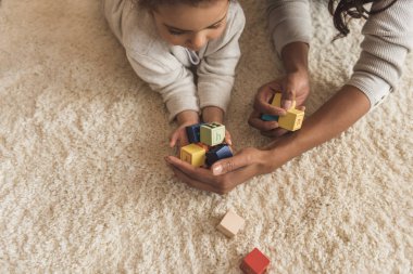 mother and daughter playing with cubes clipart