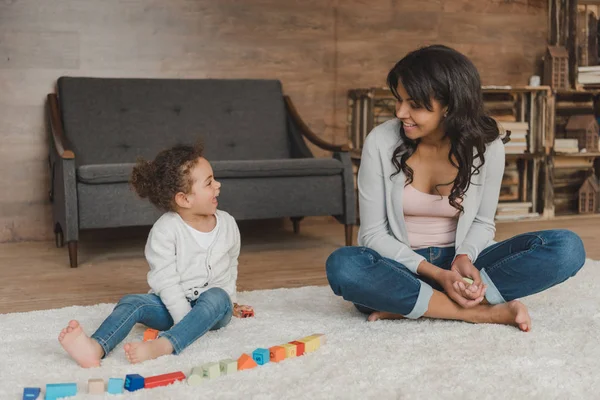 Mother and daughter playing with cubes — Stock Photo, Image