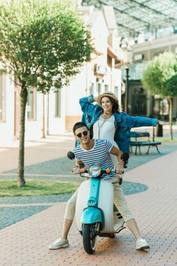 Young couple riding scooter  clipart