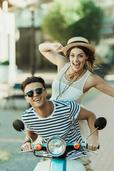 stylish couple riding moped