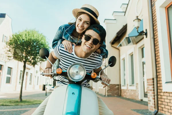 Pareja joven montando scooter — Foto de Stock