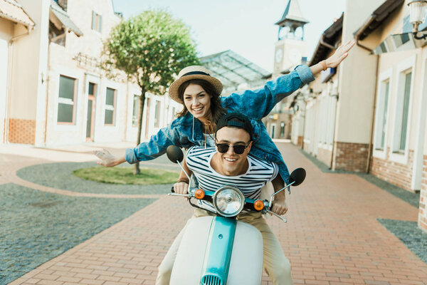 Young couple riding scooter 