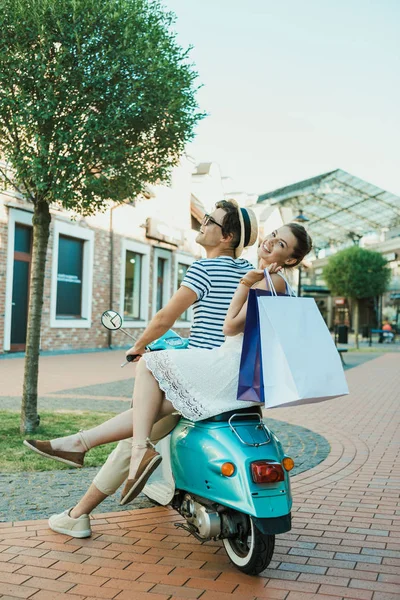 Young casual couple riding on moped — Free Stock Photo