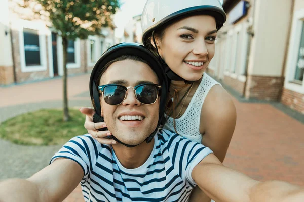 Jovem casal em capacetes tomando selfie — Fotografia de Stock