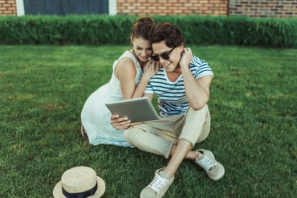 Met behulp van digitale tablet op park (echt) paar — Stockfoto