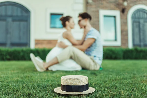 Sweethearts able to kiss while sitting on grass — Stock Photo, Image