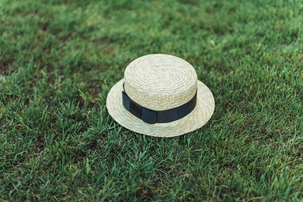 stylish straw hat with ribbon on grass