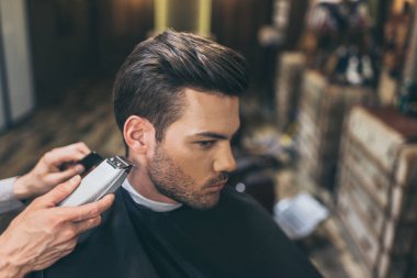 barber cutting hair of customer  clipart