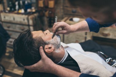 Barber shaving customer clipart