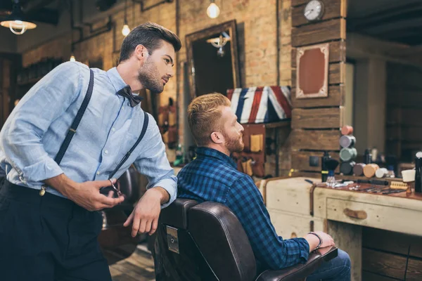 Barbeiro com cliente na barbearia — Fotografia de Stock