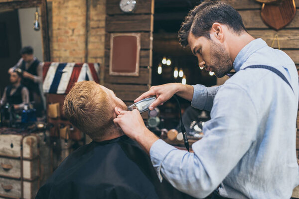 barber trimming customers beard